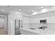 A modern all-white kitchen featuring stainless steel appliances and lots of storage at 400 150Th Ave # 305, Madeira Beach, FL 33708