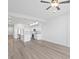 An open-concept living area with wood floors featuring a pristine white kitchen at 400 150Th Ave # 305, Madeira Beach, FL 33708