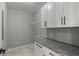 Bright laundry room with white cabinets, granite countertop, and ample shelving at 211 Dolphin Pt # 501, Clearwater, FL 33767
