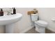 Bright bathroom featuring a pedestal sink and modern toilet at 10913 Trailing Vine Dr, Tampa, FL 33610