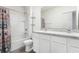Clean bathroom with double sinks, a large mirror, and a shower-tub combination with patterned curtain at 10913 Trailing Vine Dr, Tampa, FL 33610