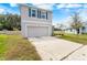 Two-story home featuring an attached garage, long driveway and blue shutters at 10913 Trailing Vine Dr, Tampa, FL 33610