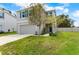 Two-story home featuring an attached garage, green lawn, and young trees at 10913 Trailing Vine Dr, Tampa, FL 33610