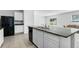 Open kitchen featuring a granite countertop island, stainless steel appliances, and tile flooring at 10913 Trailing Vine Dr, Tampa, FL 33610