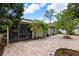 Brick paved backyard patio with screened enclosure and landscaping at 4931 Ridgemoor Cir, Palm Harbor, FL 34685