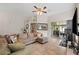 Spacious living room with a sectional sofa, large windows, and access to a patio at 4931 Ridgemoor Cir, Palm Harbor, FL 34685