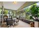 Peaceful screened porch with seating for four and lush landscaping at 4931 Ridgemoor Cir, Palm Harbor, FL 34685