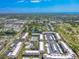 An aerial view shows a golf course, pool, and manicured landscaping surrounding this condo community near the ocean at 12300 Vonn Rd # 3204, Largo, FL 33774