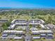 Aerial view of the condominium community showcasing a pool, tennis courts, and manicured landscaping near the ocean at 12300 Vonn Rd # 3204, Largo, FL 33774