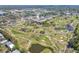 Aerial view of the community near a golf course, featuring ponds, trees, and lush greenery at 12300 Vonn Rd # 3204, Largo, FL 33774