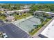 Aerial view featuring shuffleboard, a tennis court, clubhouse, and parking spaces at 12300 Vonn Rd # 3204, Largo, FL 33774
