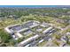 An aerial view of a condo complex featuring lush landscaping, a sparkling pool, and tennis courts at 12300 Vonn Rd # 3204, Largo, FL 33774