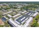 An aerial view of a condo complex featuring lush landscaping, a sparkling pool, and tennis courts at 12300 Vonn Rd # 3204, Largo, FL 33774