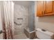 Modern bathroom featuring tiled shower with bench, grab bar, and clear glass door at 12300 Vonn Rd # 3204, Largo, FL 33774
