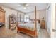 Well-lit bedroom with a four-poster bed, ceiling fan, and a view of the outside through the window at 12300 Vonn Rd # 3204, Largo, FL 33774
