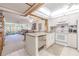 Open concept kitchen with white cabinetry and appliances, flowing into the living and dining areas at 12300 Vonn Rd # 3204, Largo, FL 33774