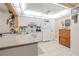 The kitchen features white cabinets, tiled floors, and a skylight illuminating the space at 12300 Vonn Rd # 3204, Largo, FL 33774