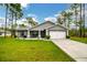 Single-story home with gray siding, white garage door, and landscaped lawn at 12476 Jaybird Rd, Weeki Wachee, FL 34614