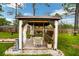 Charming gazebo with a swing and surrounding landscaping at 12476 Jaybird Rd, Weeki Wachee, FL 34614