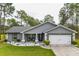Gray house with white garage and well-manicured lawn at 12476 Jaybird Rd, Weeki Wachee, FL 34614