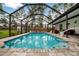 Screened-in pool with tiled deck and seating area at 12476 Jaybird Rd, Weeki Wachee, FL 34614