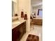 Bathroom sink with dark wood cabinet and granite countertops with a view of the bedroom at 1655 S Highland Ave # J194, Clearwater, FL 33756