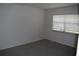 Bright bedroom with grey carpet and a window with mini blinds at 2250 Druid E Rd # 605, Clearwater, FL 33764