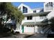 Two-story white townhouse with a two-car garage and landscaping at 9720 Indian Key Trl # 117, Seminole, FL 33776