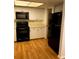 Kitchen with white cabinets and black appliances at 9720 Indian Key Trl # 117, Seminole, FL 33776