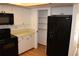 Bright kitchen with white cabinets, black appliances, and wood flooring at 9720 Indian Key Trl # 117, Seminole, FL 33776