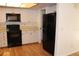 Bright kitchen with white cabinets, black appliances, and wood flooring at 9720 Indian Key Trl # 117, Seminole, FL 33776