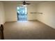 Spacious carpeted living room with sliding glass doors and ceiling fan at 9720 Indian Key Trl # 117, Seminole, FL 33776