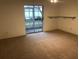 Bright living room featuring carpeted floors and sliding glass doors at 9720 Indian Key Trl # 117, Seminole, FL 33776