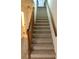 Carpeted staircase with wood railings at 9720 Indian Key Trl # 117, Seminole, FL 33776