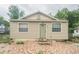 Tan house with green door, small patio, and landscaping at 440 Cypress St, Tarpon Springs, FL 34689