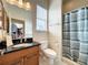 Bathroom features granite countertop, tiled shower and a view into the living room at 2066 N Pointe Alexis Dr, Tarpon Springs, FL 34689