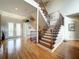 Bright foyer showcasing hardwood floors, staircase with decorative iron spindles, and transom window entry at 2066 N Pointe Alexis Dr, Tarpon Springs, FL 34689