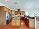 Well-equipped kitchen featuring wood cabinets, stainless steel appliances, granite countertops, and hardwood flooring at 2066 N Pointe Alexis Dr, Tarpon Springs, FL 34689