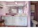 Bright bathroom featuring a large mirror with vanity lighting and white cabinetry at 14130 Rosemary Ln # 3309, Largo, FL 33774