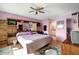 Spacious bedroom with hardwood floors, ceiling fan, large bed, and access to an ensuite bathroom at 14130 Rosemary Ln # 3309, Largo, FL 33774