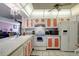 Bright kitchen with white appliances and coral cabinets at 14130 Rosemary Ln # 3309, Largo, FL 33774