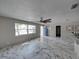 Living room with marble floors, ceiling fan and blue door at 16003 2Nd E St, Redington Beach, FL 33708