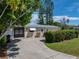 Tan house with white awnings, a black gate, and a landscaped yard at 16003 2Nd E St, Redington Beach, FL 33708
