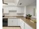 Well-lit kitchen with white cabinets and granite countertops at 9415 Blind Pass Rd # 1103, St Pete Beach, FL 33706