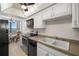 Kitchen with white cabinets, double sink, and black appliances at 9415 Blind Pass Rd # 1103, St Pete Beach, FL 33706