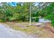 Small house exterior with screened porch and overgrown yard at 1838 Sylvan Dr, Clearwater, FL 33755