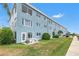 Light blue building with patio, grassy area, and waterfront access at 12405 3Rd E St # 304, Treasure Island, FL 33706