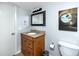 Neat bathroom featuring a wood vanity with a granite countertop, a modern mirror, and neutral decor at 19531 Gulf Blvd # 403, Indian Shores, FL 33785