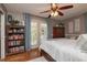 Cozy bedroom featuring a decorative ceiling fan, hardwood floors and a bookshelf at 761 Soundview Dr, Palm Harbor, FL 34683