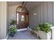 Elegant front door with decorative glass and sidelights, flanked by potted plants at 761 Soundview Dr, Palm Harbor, FL 34683
